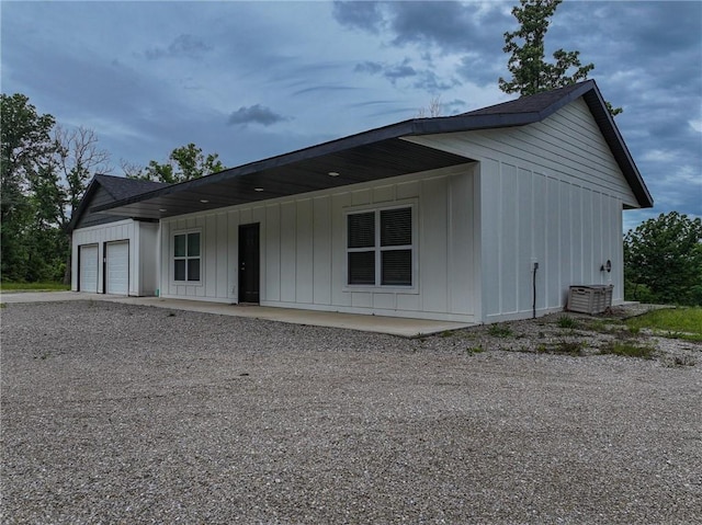 3813 Mt Horeb Rd, Camdenton, MO 65020 - view of front of house with board and batten siding, a garage, driveway, and central air condition unit
