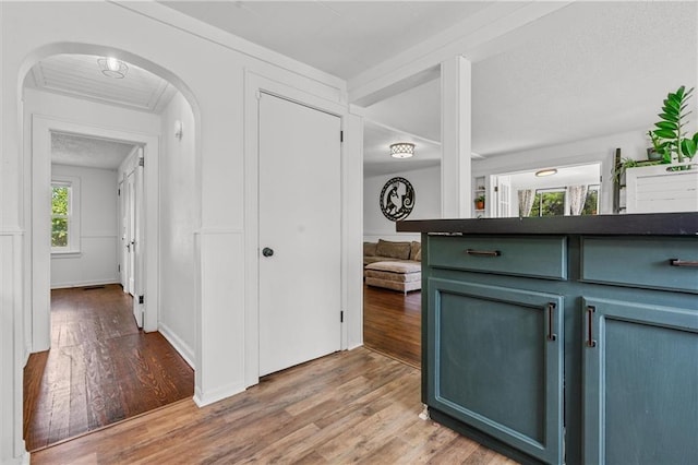 5801 E 56th St, Kansas City, MO 64129 - corridor featuring light wood-type flooring, arched walkways, and baseboards
