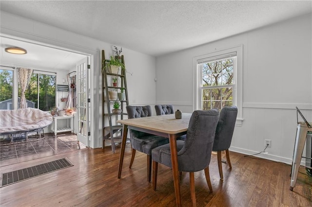 5801 E 56th St, Kansas City, MO 64129 - dining space with wood finished floors, a decorative wall, and a textured ceiling