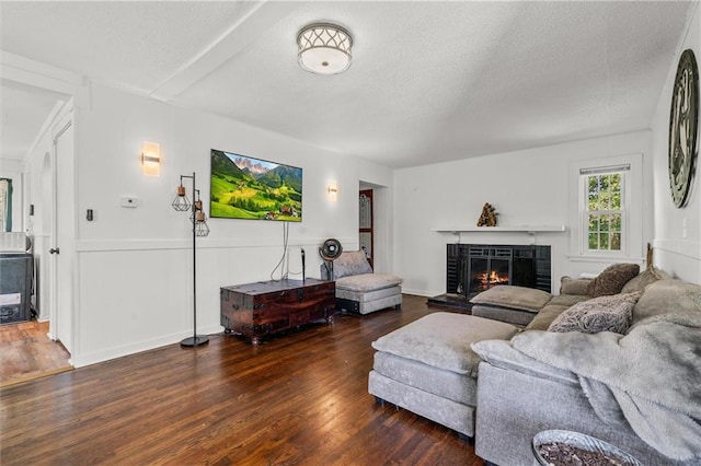 5801 E 56th St, Kansas City, MO 64129 - living room featuring wood finished floors, a fireplace, and a textured ceiling