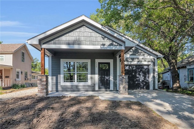 view of front of home featuring an attached garage, concrete driveway, and a porch
