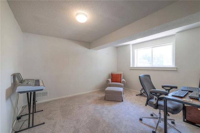 carpeted home office featuring a textured ceiling and baseboards