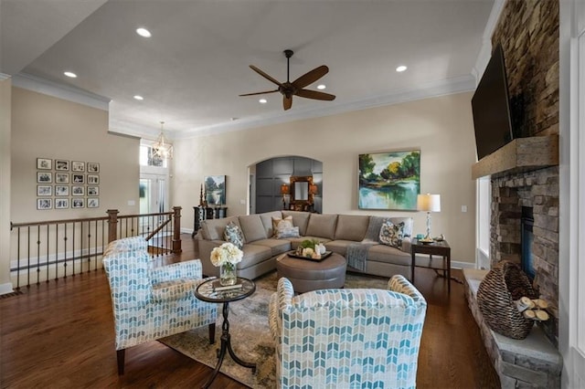 living room featuring a stone fireplace, wood finished floors, ornamental molding, recessed lighting, and ceiling fan