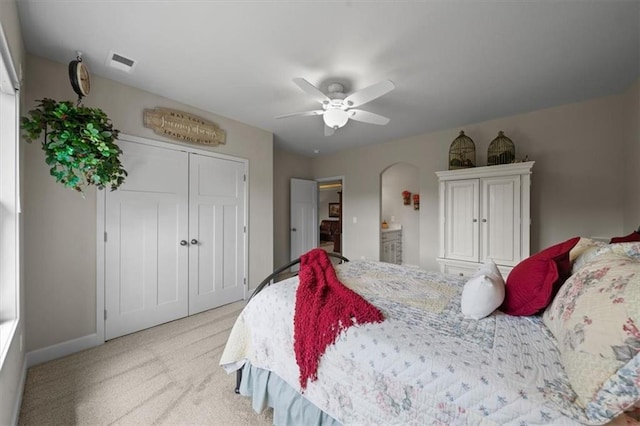 bedroom with light colored carpet, a closet, ceiling fan, and baseboards