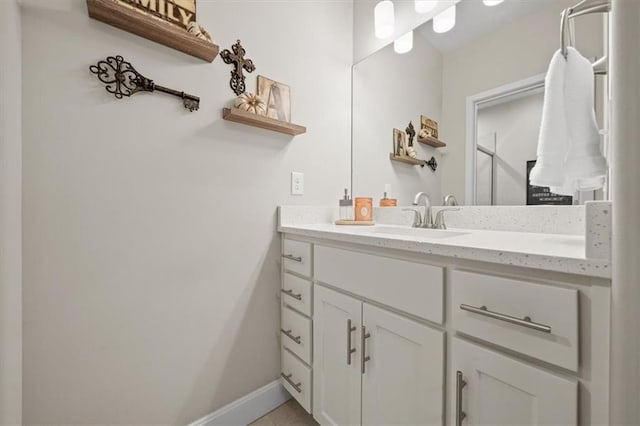 bathroom featuring vanity, a shower, and baseboards
