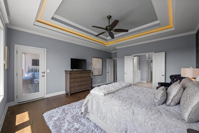 bedroom with a raised ceiling, wood finished floors, baseboards, crown molding, and ceiling fan