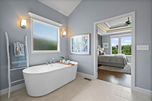 full bathroom with baseboards, ensuite bathroom, a freestanding tub, ceiling fan, and tile patterned floors