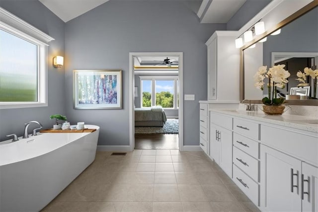 25749 W 96th Ter, Lenexa, KS 66227 - bathroom with double vanity, lofted ceiling, a freestanding tub, tile patterned flooring, and a ceiling fan