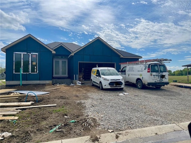 view of front facade with board and batten siding, french doors, and an attached garage