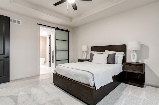 16751 S Fellows St, Olathe, KS 66062 - carpeted bedroom with a raised ceiling, a barn door, ceiling fan, and ensuite bath