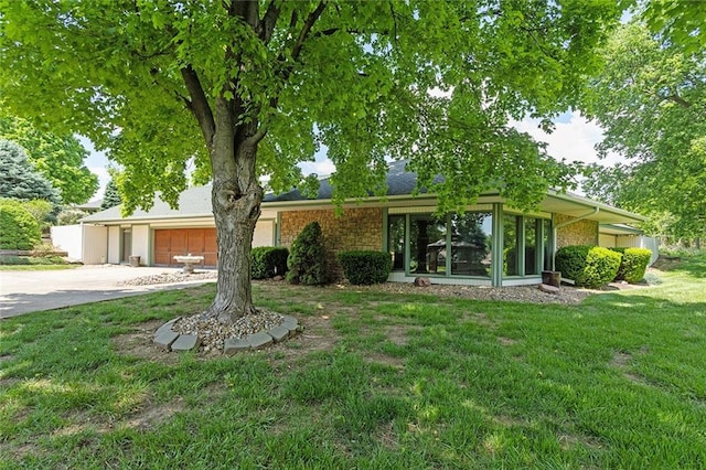 7613 NW Valley Rd, Kansas City, MO 64152 - view of front of house featuring driveway, brick siding, a garage, and a front lawn