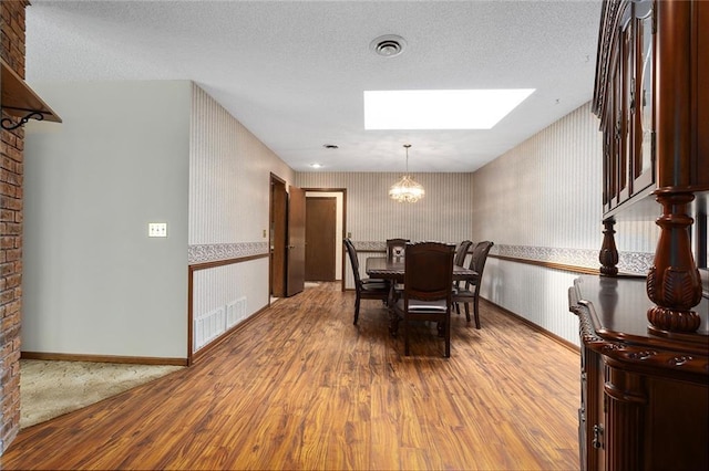 7613 NW Valley Rd, Kansas City, MO 64152 - dining room featuring a skylight, wallpapered walls, wood finished floors, a chandelier, and baseboards