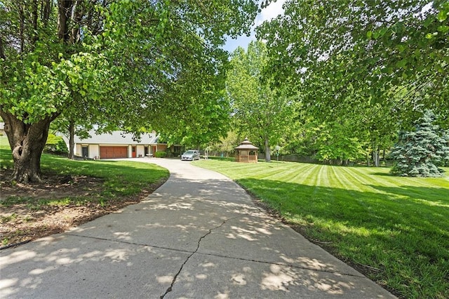 7613 NW Valley Rd, Kansas City, MO 64152 - view of community featuring a yard, driveway, and an attached garage
