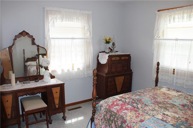 carpeted bedroom with baseboards and multiple windows