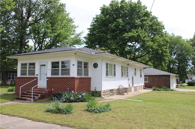 view of front facade with a front lawn, brick siding, and entry steps
