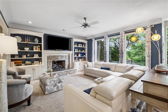 14910 Rhodes Cir, Lenexa, KS 66215 - living area with crown molding, ceiling fan, carpet floors, a stone fireplace, and recessed lighting