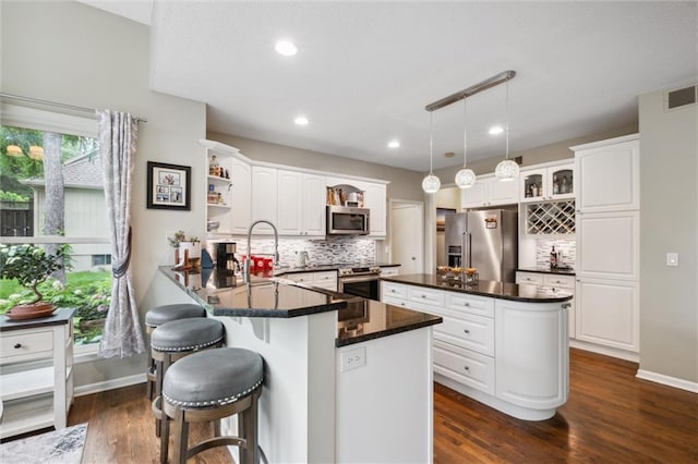 14910 Rhodes Cir, Lenexa, KS 66215 - kitchen with appliances with stainless steel finishes, open shelves, dark countertops, a peninsula, and tasteful backsplash