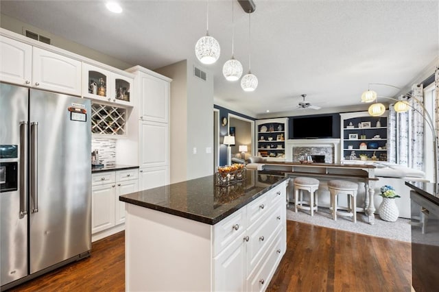 14910 Rhodes Cir, Lenexa, KS 66215 - kitchen with high end fridge, a ceiling fan, dark wood-type flooring, a fireplace, and white cabinetry