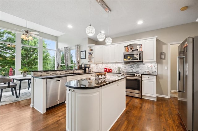 14910 Rhodes Cir, Lenexa, KS 66215 - kitchen with appliances with stainless steel finishes, open shelves, a peninsula, dark countertops, and recessed lighting