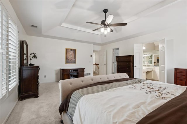 14910 Rhodes Cir, Lenexa, KS 66215 - bedroom with a tray ceiling, carpet floors, ensuite bath, and a ceiling fan