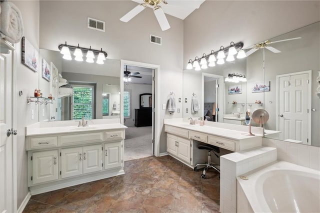 14910 Rhodes Cir, Lenexa, KS 66215 - full bathroom with a ceiling fan, a towering ceiling, a bath, and two vanities