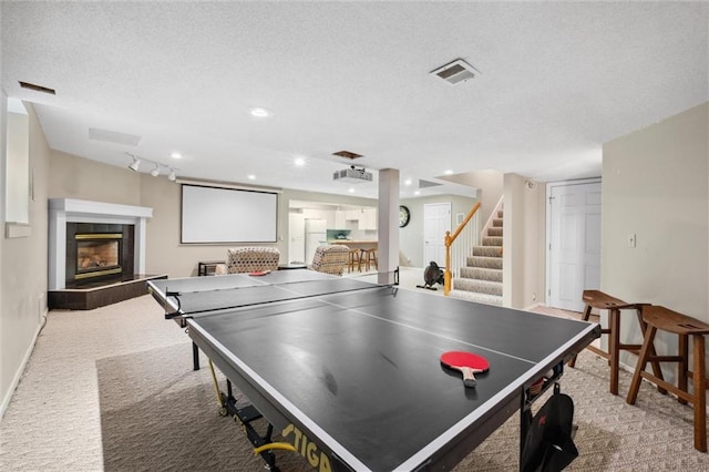 14910 Rhodes Cir, Lenexa, KS 66215 - rec room featuring carpet, a tile fireplace, and a textured ceiling