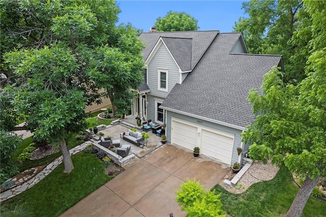 14910 Rhodes Cir, Lenexa, KS 66215 - view of front of house featuring roof with shingles, driveway, an attached garage, a chimney, and an outdoor hangout area