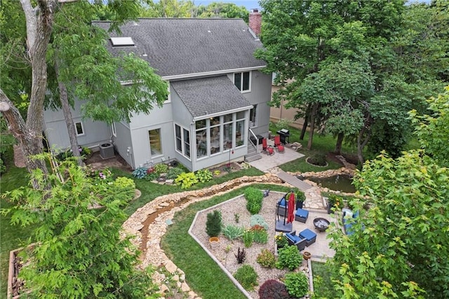 14910 Rhodes Cir, Lenexa, KS 66215 - rear view of property with roof with shingles, a sunroom, a patio area, a chimney, and an outdoor fire pit