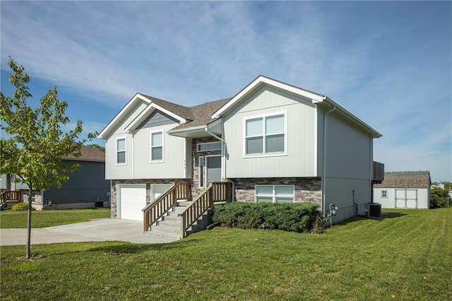 raised ranch featuring driveway, cooling unit, a front yard, and an attached garage