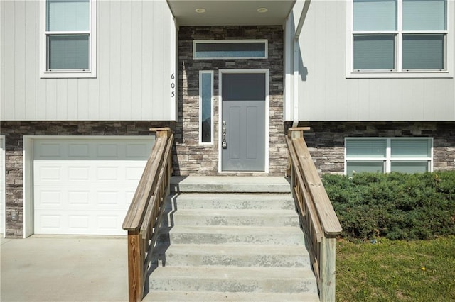 605 Carr St, Knob Noster, MO 65336 - doorway to property featuring stone siding, a garage, and driveway