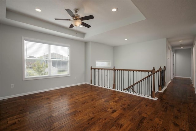 605 Carr St, Knob Noster, MO 65336 - unfurnished room with a tray ceiling, hardwood / wood-style flooring, baseboards, recessed lighting, and ceiling fan