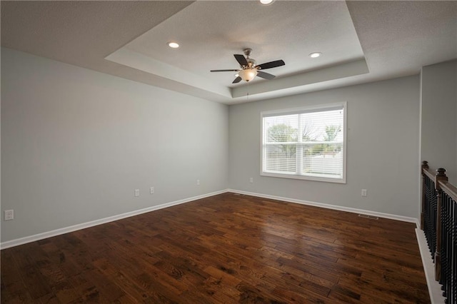 605 Carr St, Knob Noster, MO 65336 - unfurnished living room featuring a tray ceiling, ceiling fan, baseboards, dark wood-type flooring, and a textured ceiling