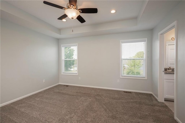 605 Carr St, Knob Noster, MO 65336 - carpeted spare room featuring a raised ceiling, ceiling fan, baseboards, a sink, and recessed lighting
