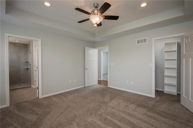 605 Carr St, Knob Noster, MO 65336 - unfurnished bedroom with carpet flooring, a tray ceiling, recessed lighting, a spacious closet, and baseboards