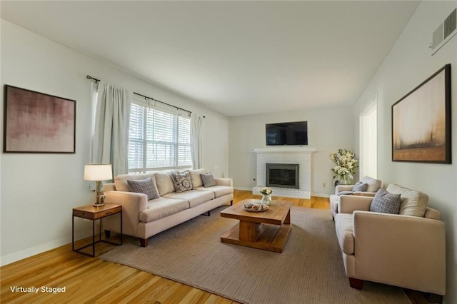 5707 W 101st Ter, Overland Park, KS 66207 - living area featuring wood finished floors, a brick fireplace, and baseboards