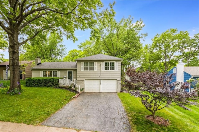 5707 W 101st Ter, Overland Park, KS 66207 - tri-level home featuring a garage, a front lawn, driveway, and a chimney