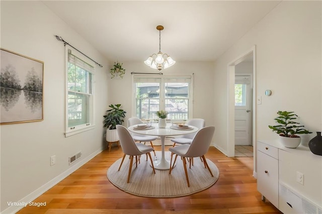 5707 W 101st Ter, Overland Park, KS 66207 - dining space featuring a chandelier, plenty of natural light, light wood-style flooring, and baseboards