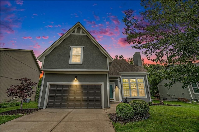 15951 S Avalon St, Olathe, KS 66062 - traditional-style house featuring a front yard, a chimney, driveway, stucco siding, and a garage