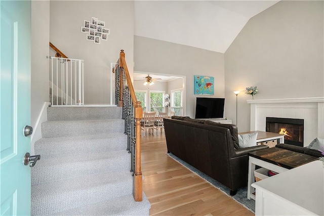 15951 S Avalon St, Olathe, KS 66062 - living room with stairs, light wood-style flooring, lofted ceiling, a fireplace, and ceiling fan