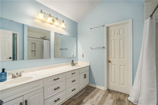 15951 S Avalon St, Olathe, KS 66062 - full bathroom featuring lofted ceiling, wood finished floors, double vanity, curtained shower, and a textured ceiling