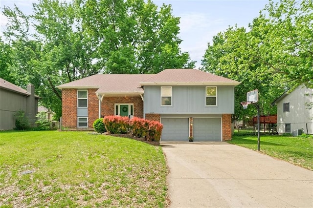 bi-level home with brick siding, a garage, concrete driveway, and a front lawn