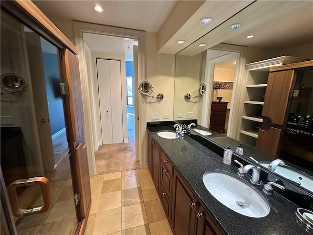 4950 Central St Unit 102, Kansas City, MO 64112 - bathroom with double vanity, recessed lighting, a walk in closet, and tile patterned floors