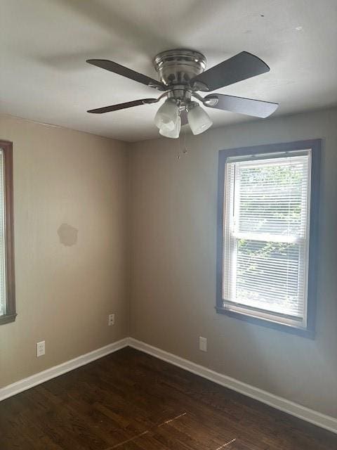3805 Laurel Ave, Kansas City, MO 64133 - spare room with baseboards, dark wood-style floors, and a healthy amount of sunlight