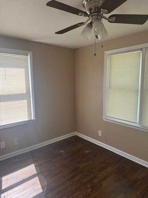 3805 Laurel Ave, Kansas City, MO 64133 - spare room featuring ceiling fan, baseboards, and dark wood-type flooring