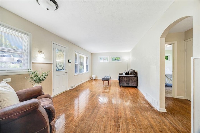 6132 N Eugene Field Rd, Kansas City, MO 64119 - living room with arched walkways, wood finished floors, and baseboards