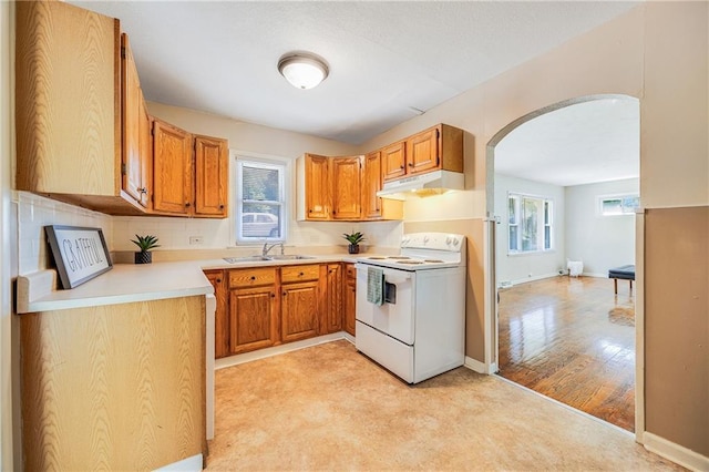 6132 N Eugene Field Rd, Kansas City, MO 64119 - kitchen with white electric stove, arched walkways, under cabinet range hood, a sink, and light countertops