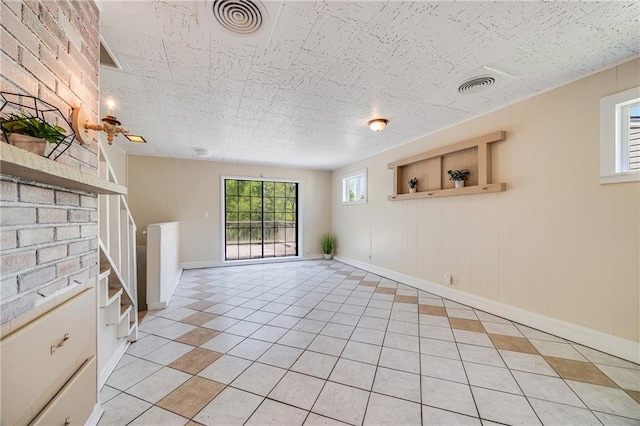 6132 N Eugene Field Rd, Kansas City, MO 64119 - unfurnished living room with light tile patterned flooring, stairs, and baseboards