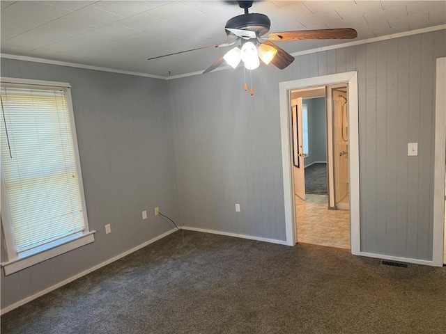 112 N Burns St N, Independence, KS 67301 - unfurnished room with carpet flooring, a ceiling fan, ornamental molding, healthy amount of natural light, and wood walls