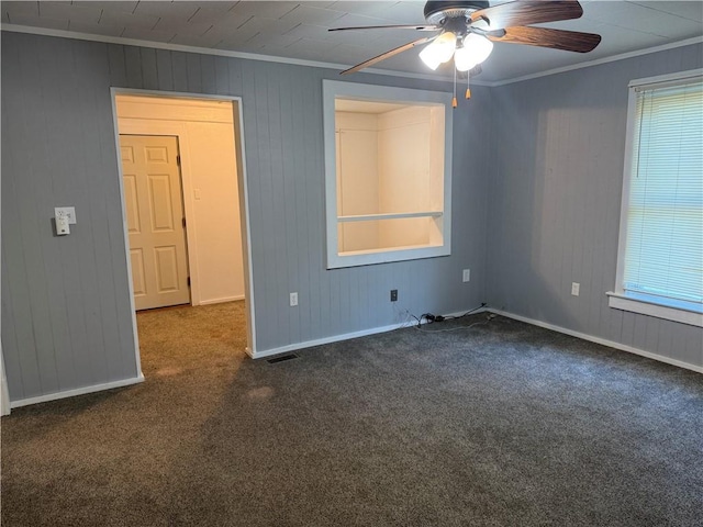 112 N Burns St N, Independence, KS 67301 - empty room featuring ceiling fan, carpet, crown molding, wood walls, and baseboards