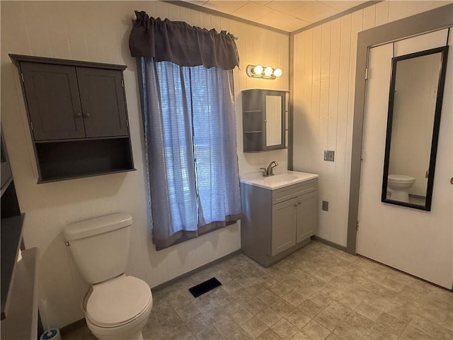 112 N Burns St N, Independence, KS 67301 - bathroom with toilet, tile patterned floors, wooden walls, and vanity